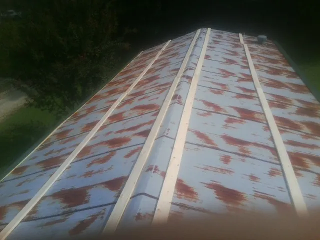 Rusted metal roof panels with new wood purlins before replacement — Storm Damage Roof Repair in Shoreham by Roofing Brothers
